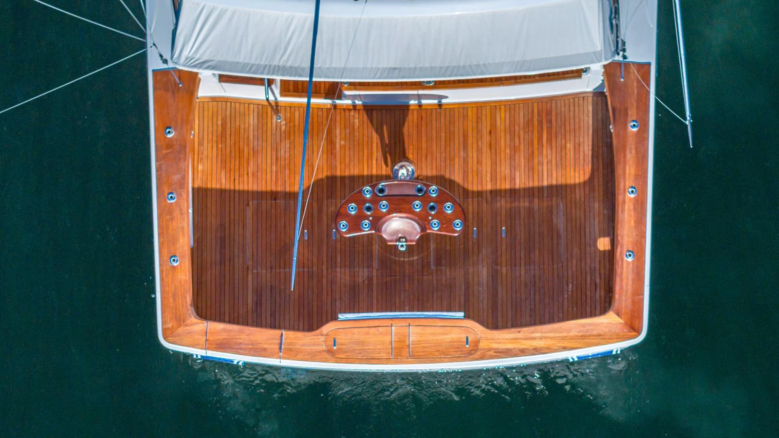 A top-down view of the yacht's aft deck showcasing its polished wooden finish and sleek design. aboard FIRST BITE Yacht for Sale