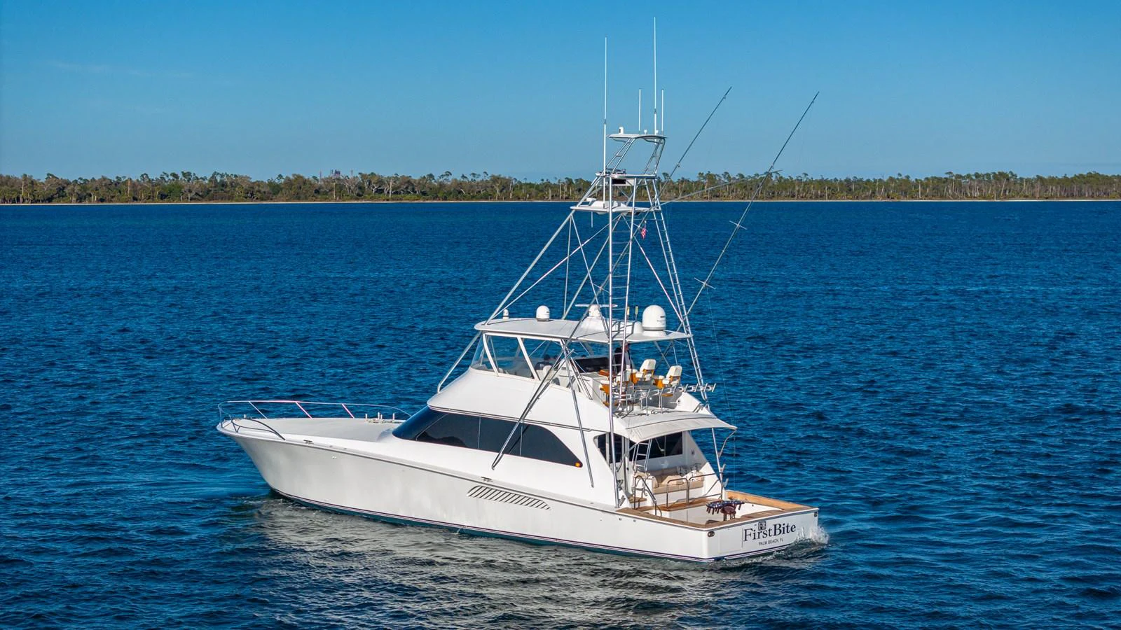 A sleek yacht cruises on calm blue waters under a clear sky. aboard FIRST BITE Yacht for Sale