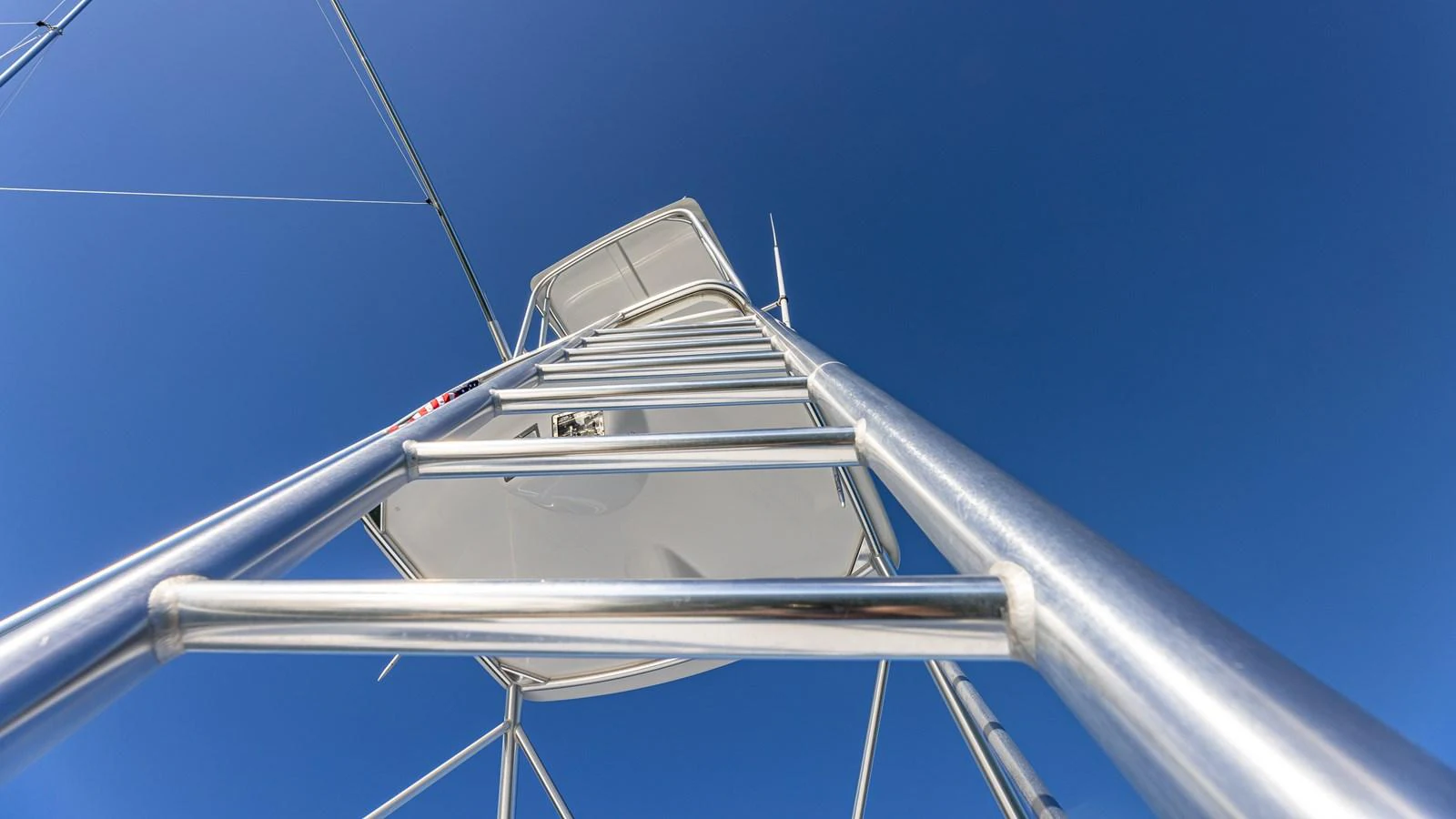 A close-up view of the yacht's ladder and structure against a clear blue sky. aboard FIRST BITE Yacht for Sale