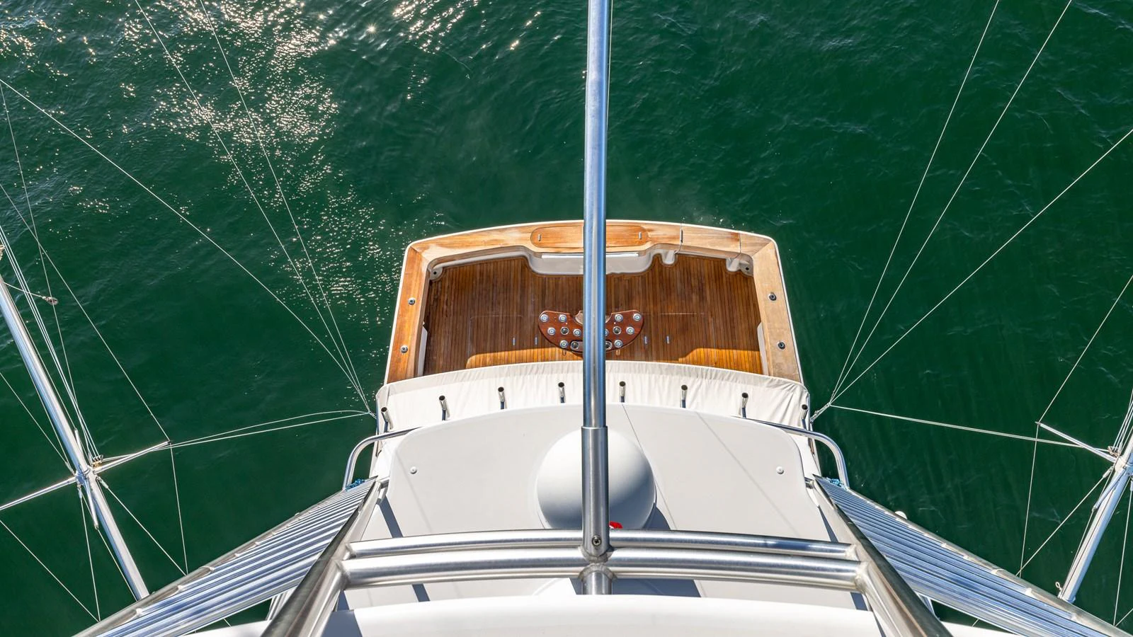A view from above showcasing the yacht's aft deck with a wooden finish and surrounding water. aboard FIRST BITE Yacht for Sale
