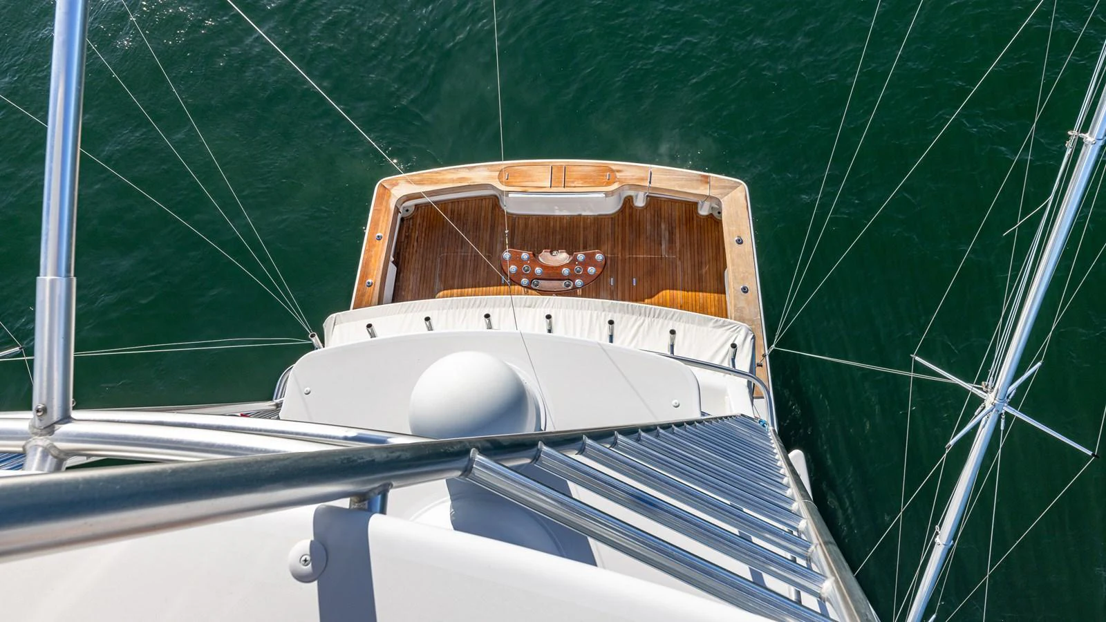 A view from above showcasing the yacht's aft deck with a wooden platform and clear waters below. aboard FIRST BITE Yacht for Sale