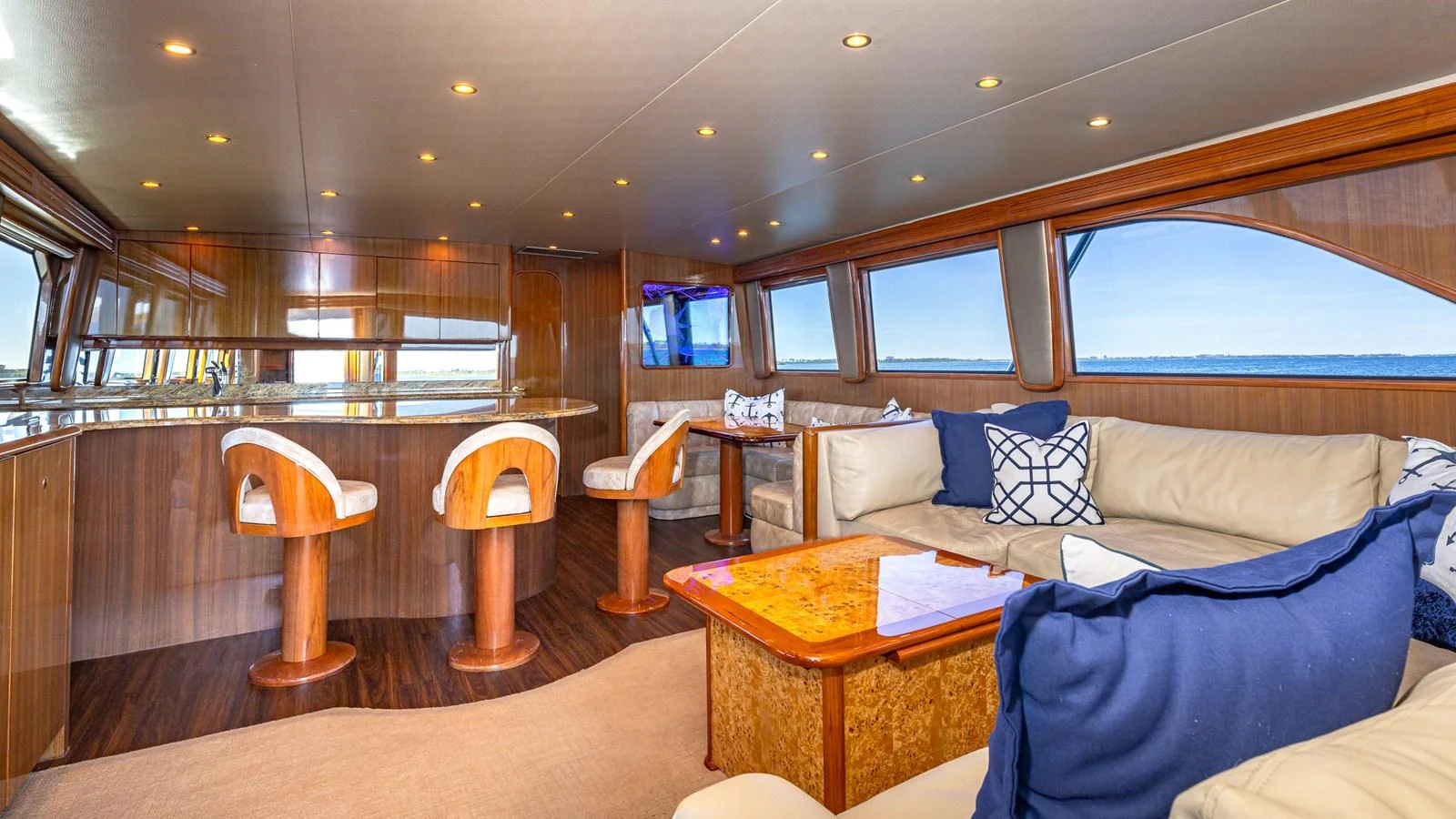 The yacht's salon features a luxurious seating area with plush cushions and a stylish bar with high stools. aboard FIRST BITE Yacht for Sale