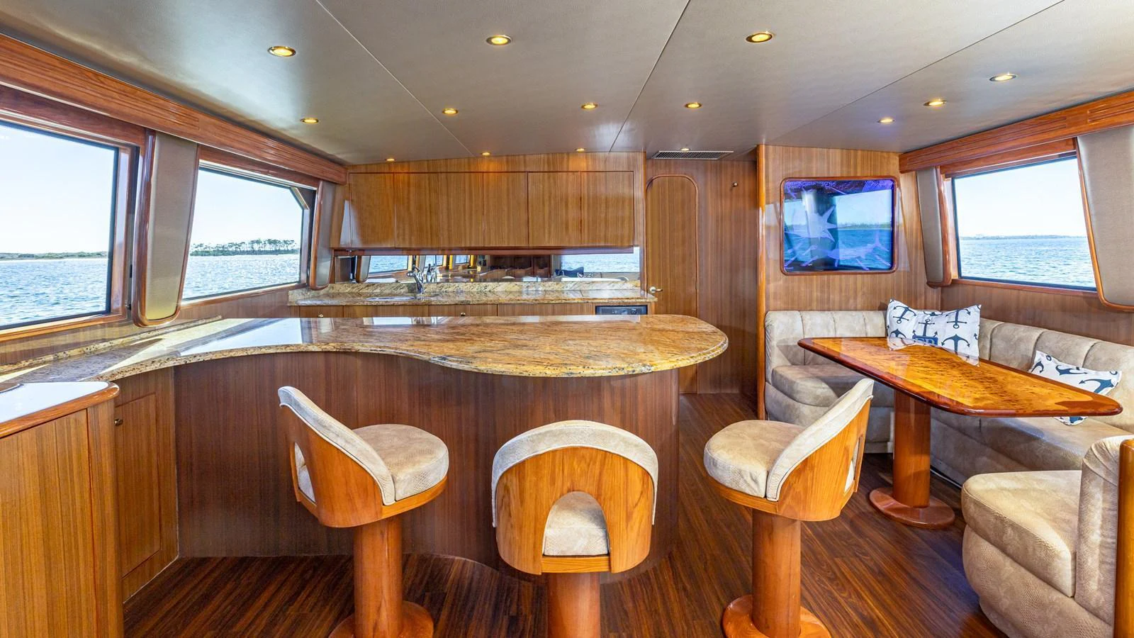 The yacht's saloon features a luxurious seating area with a dining table and a well-equipped bar counter. aboard FIRST BITE Yacht for Sale