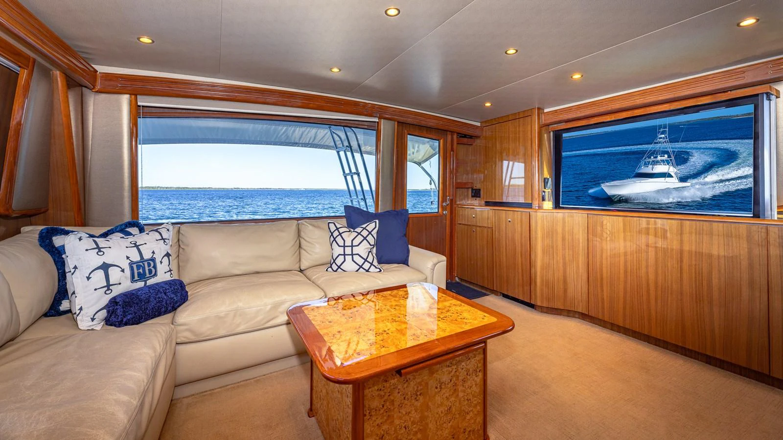 The salon features a comfortable seating area with a view of the ocean through large windows. aboard FIRST BITE Yacht for Sale