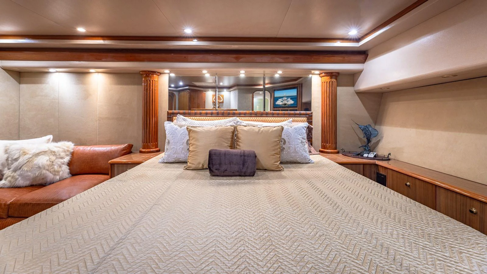 The master stateroom features a luxurious bed with elegant pillows and ambient lighting. aboard FIRST BITE Yacht for Sale
