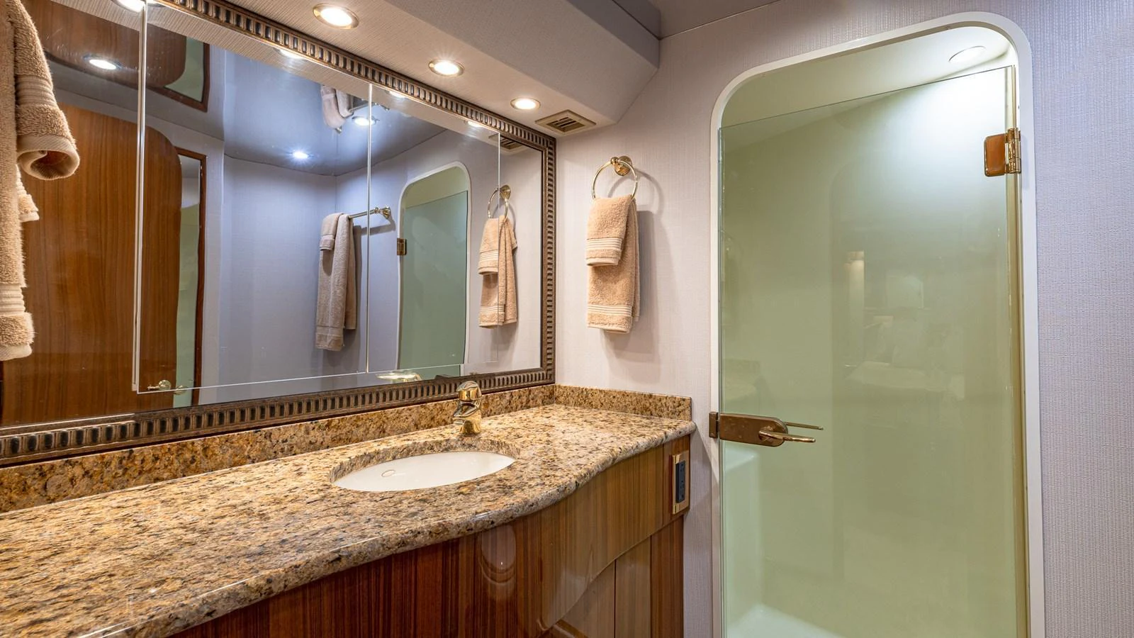 The yacht's bathroom features a sleek granite countertop and a spacious glass-enclosed shower. aboard FIRST BITE Yacht for Sale