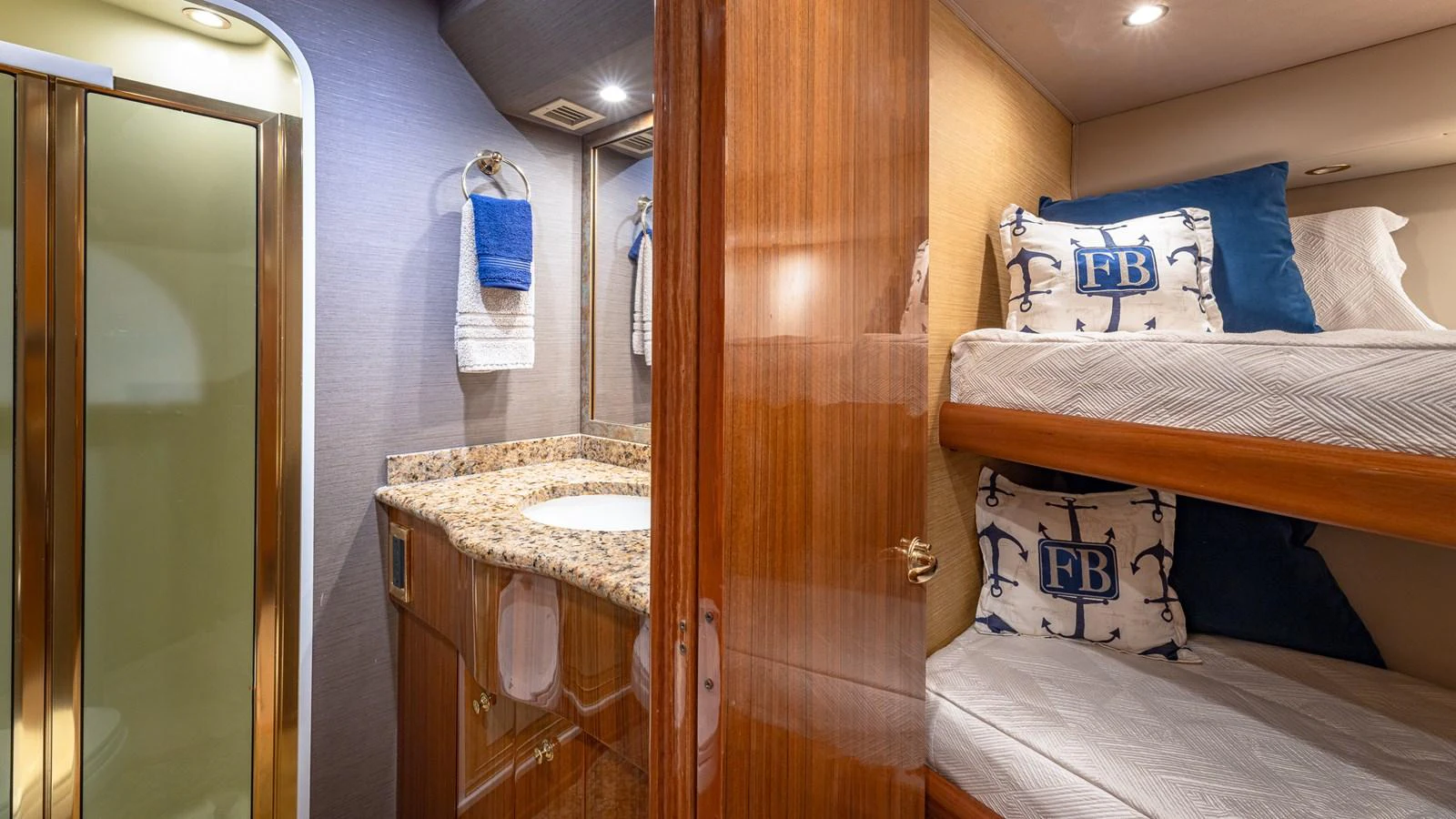 This cozy guest cabin features bunk beds and a private bathroom with elegant finishes. aboard FIRST BITE Yacht for Sale