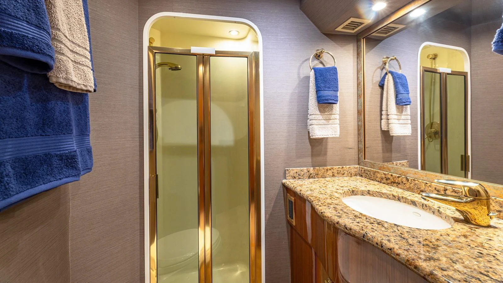 The yacht's bathroom features a luxurious granite countertop and a spacious shower with gold accents. aboard FIRST BITE Yacht for Sale