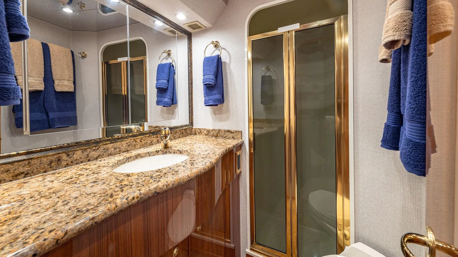 The yacht's bathroom features a granite countertop, wooden cabinetry, and a glass-enclosed shower. aboard FIRST BITE Yacht for Sale