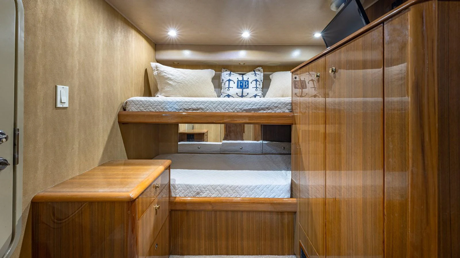 The guest cabin features cozy bunk beds and ample storage space with a warm wood finish. aboard FIRST BITE Yacht for Sale