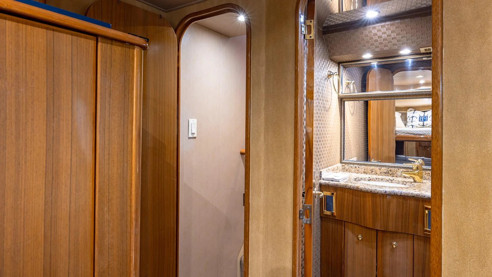 The yacht's bathroom features elegant wood paneling and a well-lit vanity area. aboard FIRST BITE Yacht for Sale