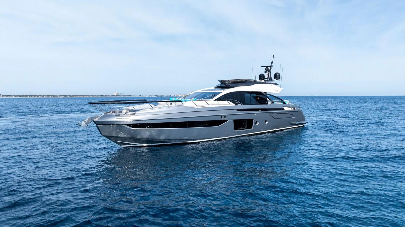 A sleek and modern yacht glides gracefully on the open water under a clear blue sky. aboard OCEAN'S SE7EN Yacht for Sale