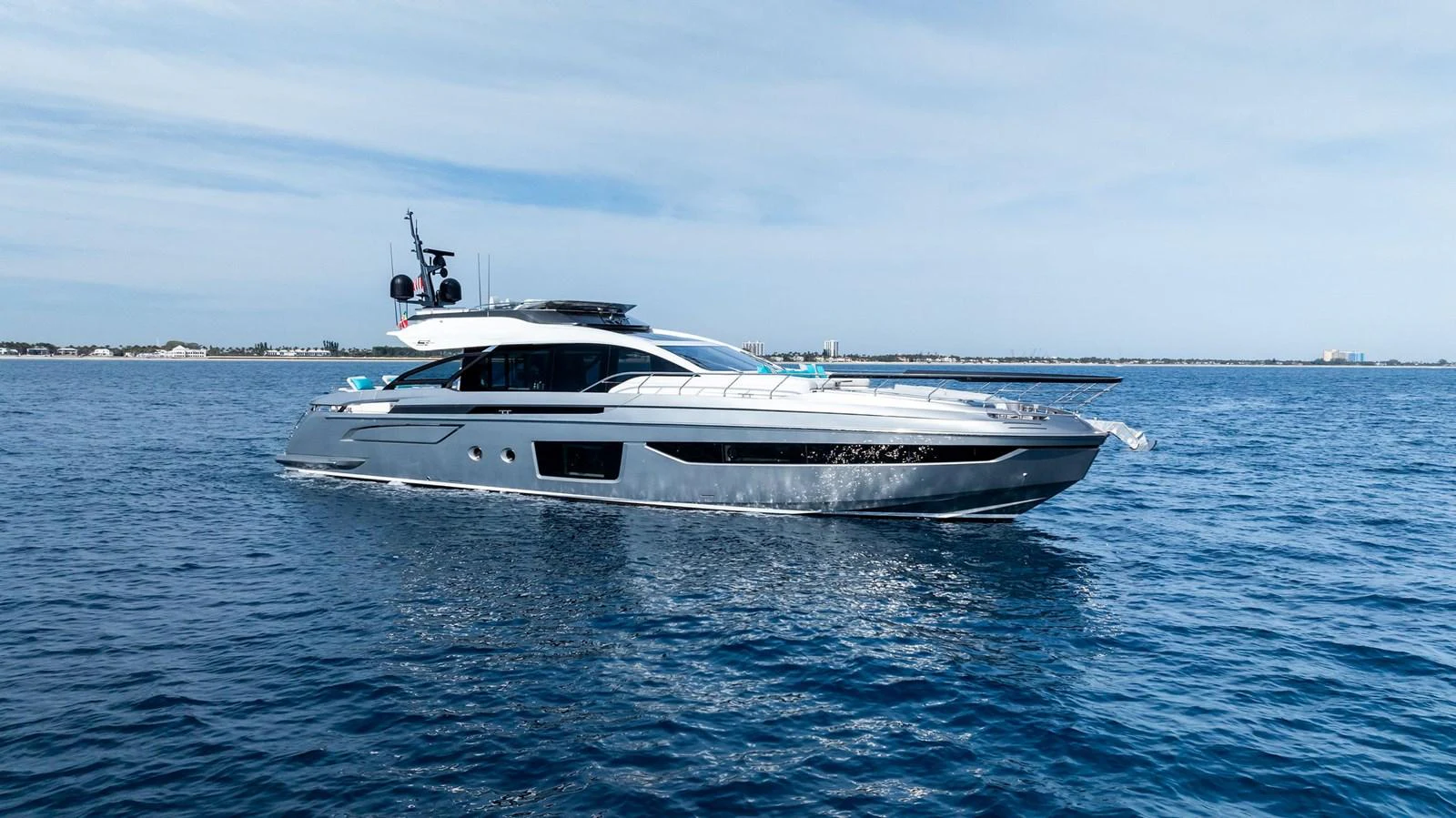 A sleek and modern yacht glides gracefully on the open water under a clear sky. aboard OCEAN'S SE7EN Yacht for Sale