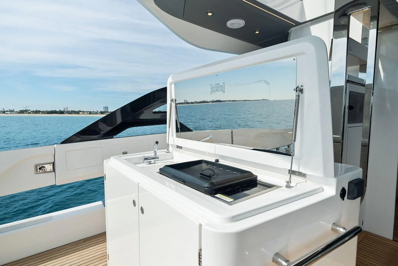 The yacht features a sleek outdoor galley with a grill and ample counter space, perfect for alfresco dining. aboard OCEAN'S SE7EN Yacht for Sale