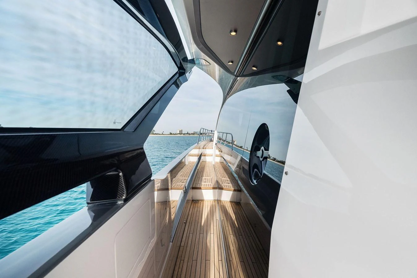 A sleek side deck with modern design and expansive windows offers a stylish passageway along the yacht. aboard OCEAN'S SE7EN Yacht for Sale
