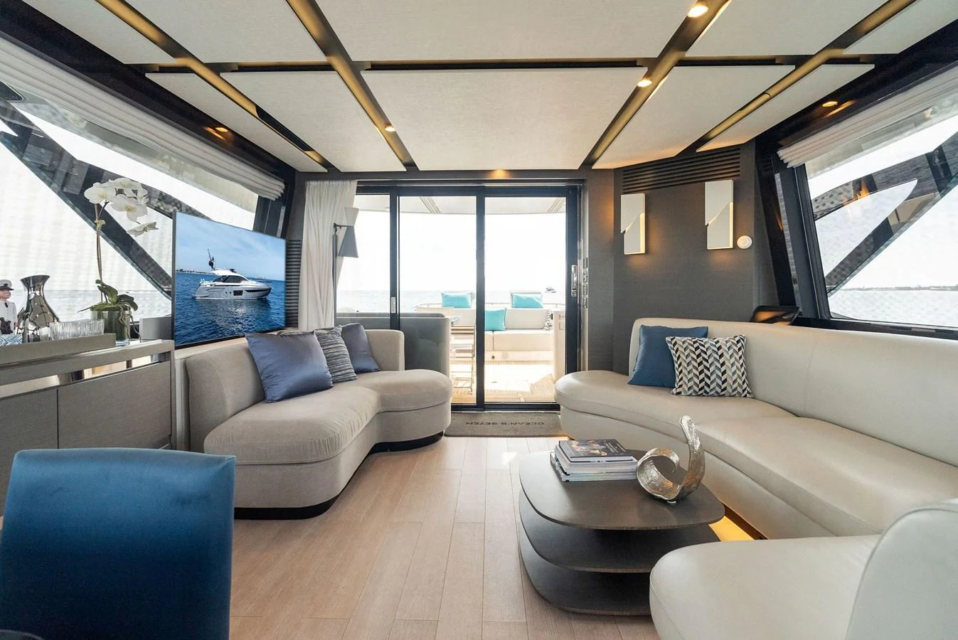 The salon features modern furnishings with ample natural light and a view of the aft deck. aboard OCEAN'S SE7EN Yacht for Sale