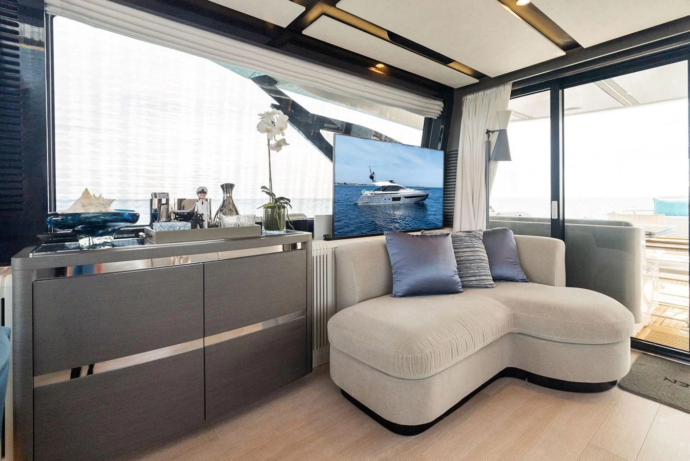 The salon features a comfortable seating area with a modern design and large windows for natural light. aboard OCEAN'S SE7EN Yacht for Sale