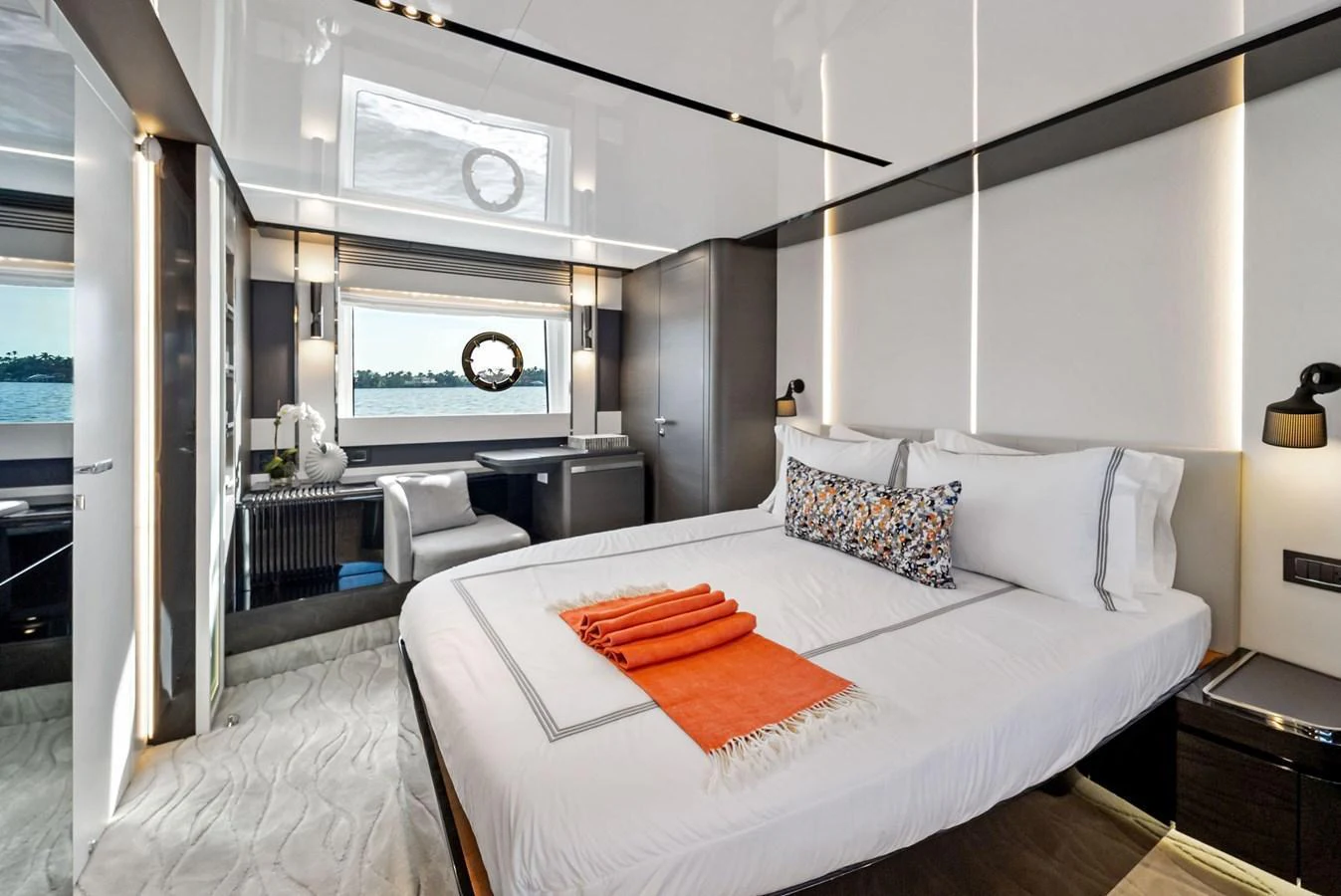 The stateroom features a luxurious bed with elegant linens and a scenic view through the window. aboard OCEAN'S SE7EN Yacht for Sale
