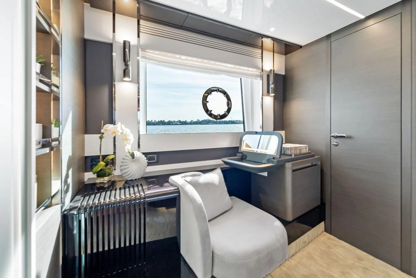 A stylish onboard office space with a large window offering a serene view of the water. aboard OCEAN'S SE7EN Yacht for Sale