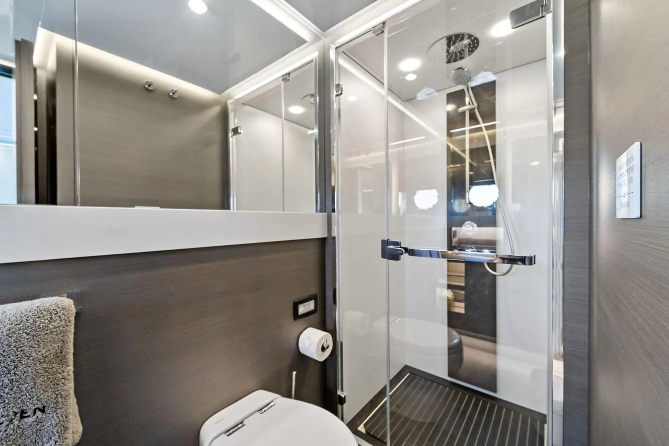 A sleek and modern yacht bathroom featuring a glass-enclosed shower and contemporary fixtures. aboard OCEAN'S SE7EN Yacht for Sale