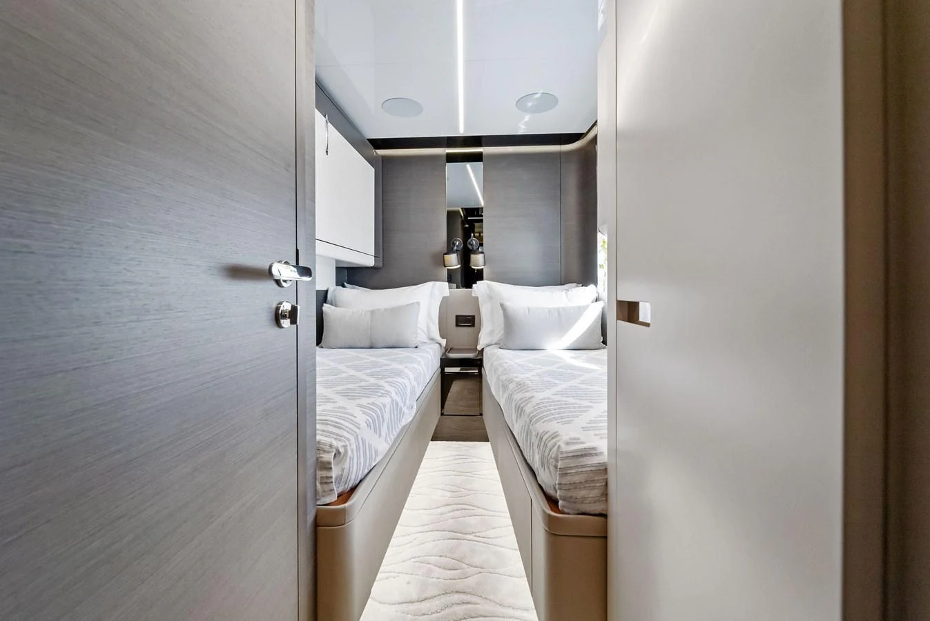 A cozy twin stateroom featuring two single beds with modern decor and ample natural light. aboard OCEAN'S SE7EN Yacht for Sale