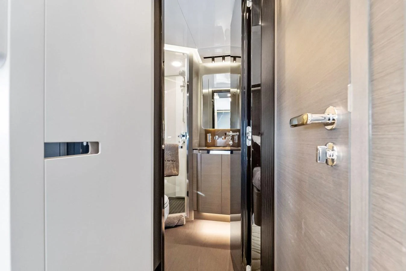 A modern yacht interior hallway leading to a well-appointed bathroom. aboard OCEAN'S SE7EN Yacht for Sale