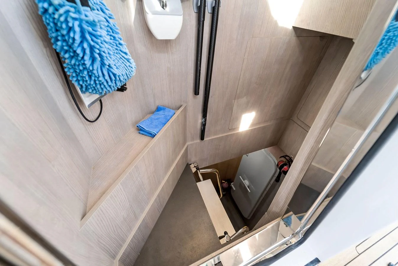 A compact and well-organized storage area with cleaning supplies and equipment. aboard OCEAN'S SE7EN Yacht for Sale