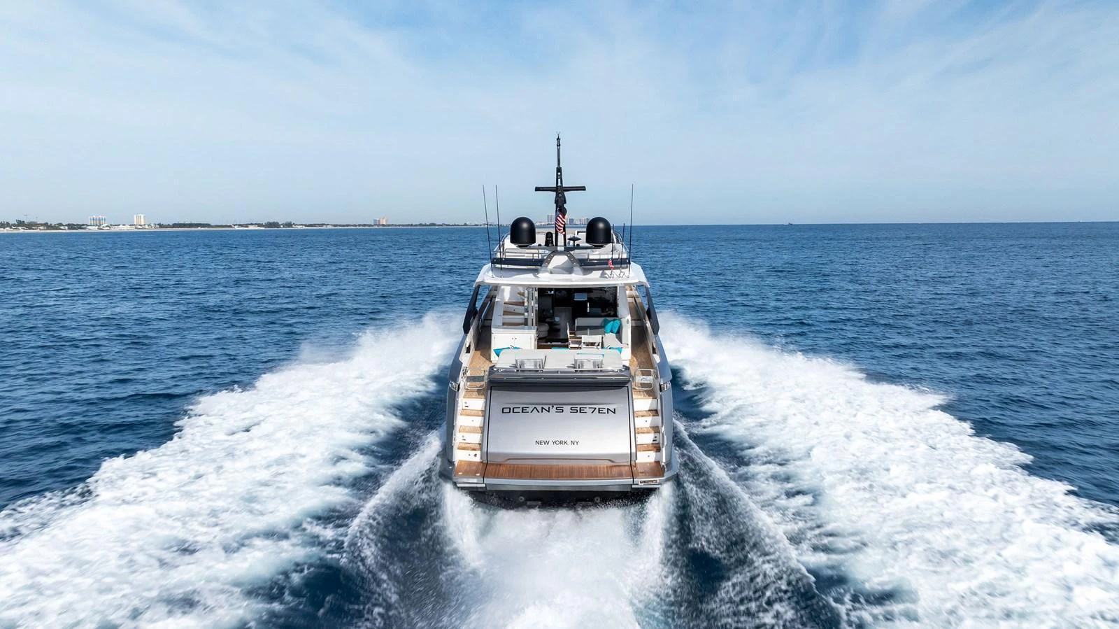 A sleek yacht cruises through the open water, leaving a trail of white waves behind. aboard OCEAN'S SE7EN Yacht for Sale