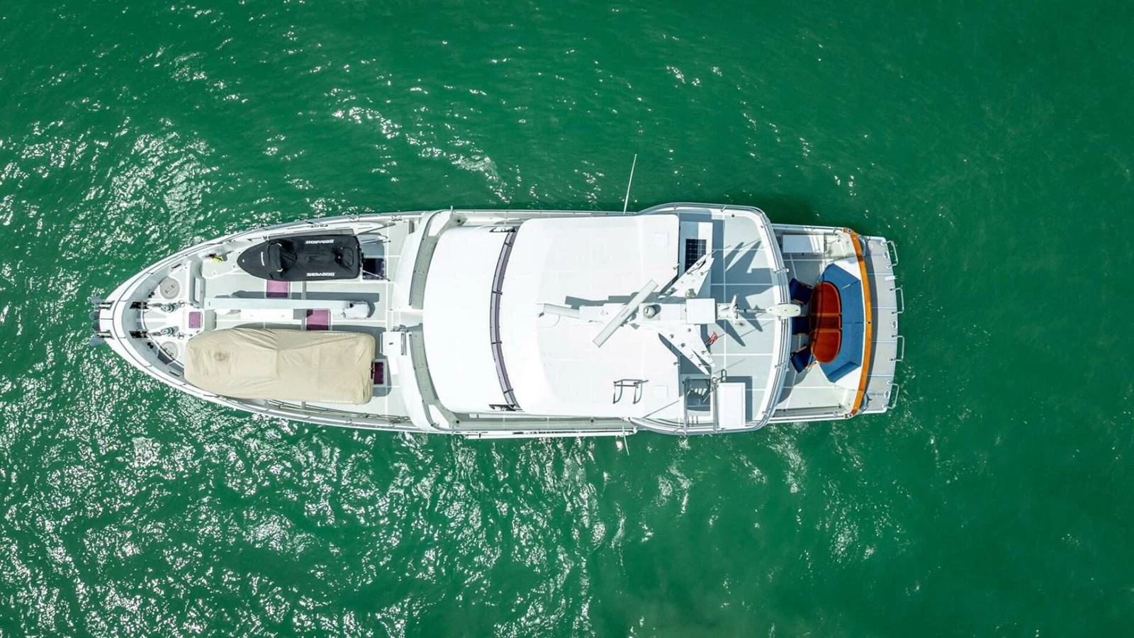 An aerial view of a sleek yacht cruising through vibrant green waters. aboard TAKE 5 Yacht for Sale