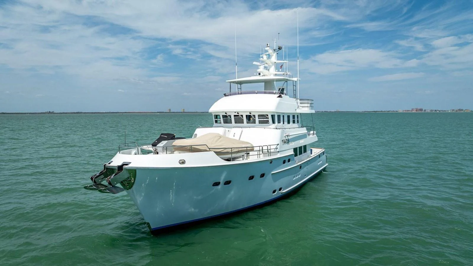 A luxurious yacht glides gracefully on calm waters under a clear blue sky. aboard TAKE 5 Yacht for Sale