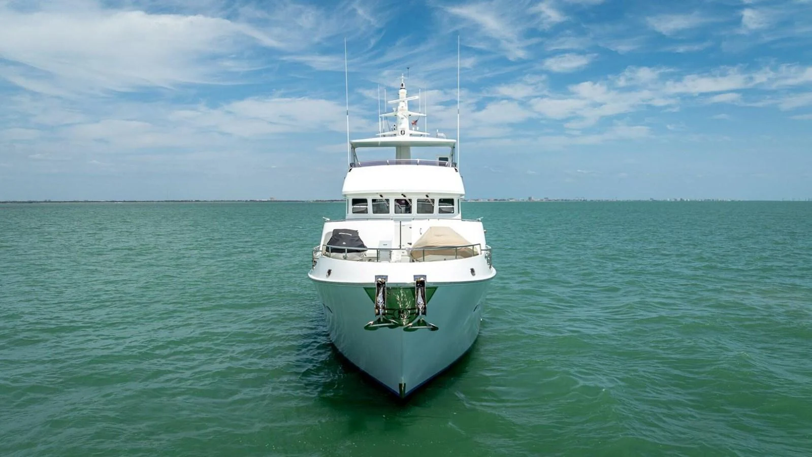 A stunning yacht is anchored on calm, turquoise waters under a clear blue sky. aboard TAKE 5 Yacht for Sale