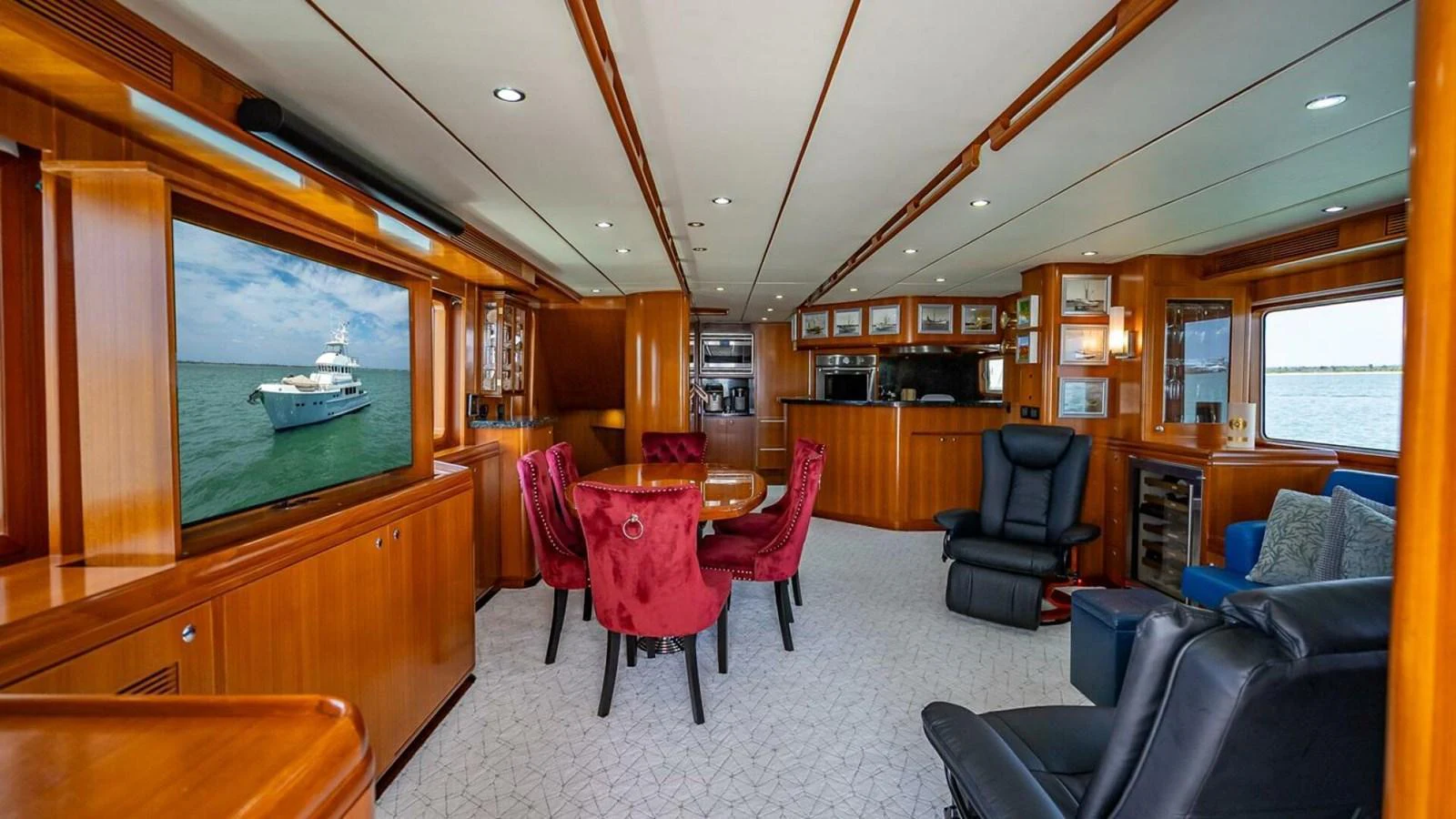 The salon features luxurious seating with a mix of plush red and blue chairs, offering a comfortable and elegant space for relaxation. aboard TAKE 5 Yacht for Sale