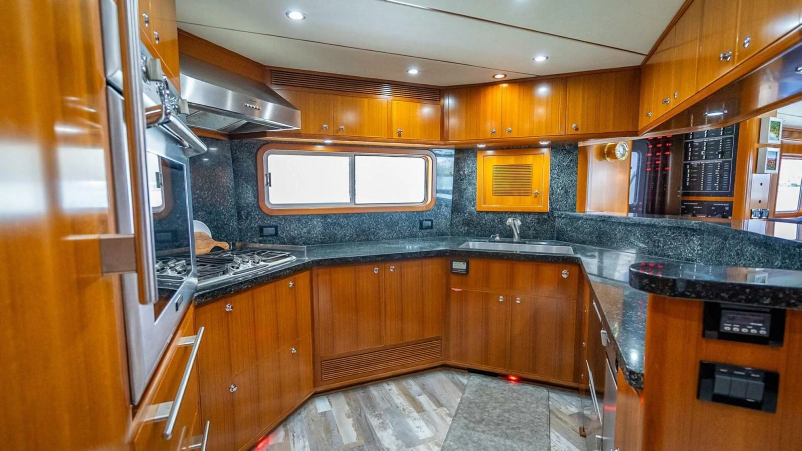 The yacht's galley features sleek wooden cabinetry, modern appliances, and ample counter space. aboard TAKE 5 Yacht for Sale