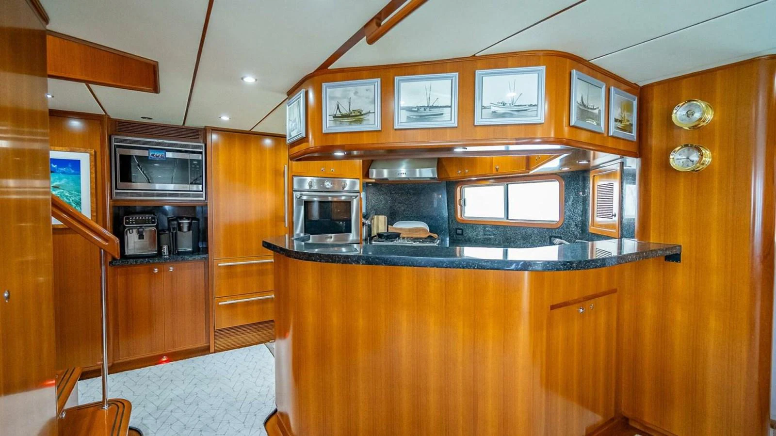 The yacht's galley features warm wood cabinetry, modern appliances, and elegant decor. aboard TAKE 5 Yacht for Sale