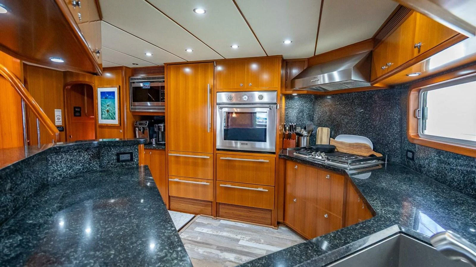 The yacht's galley features modern appliances and elegant wood cabinetry, creating a warm and functional space. aboard TAKE 5 Yacht for Sale