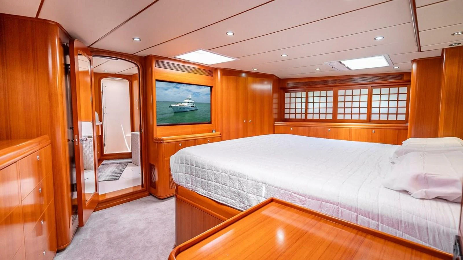 The master stateroom features a spacious bed, warm wood finishes, and ample natural light. aboard TAKE 5 Yacht for Sale