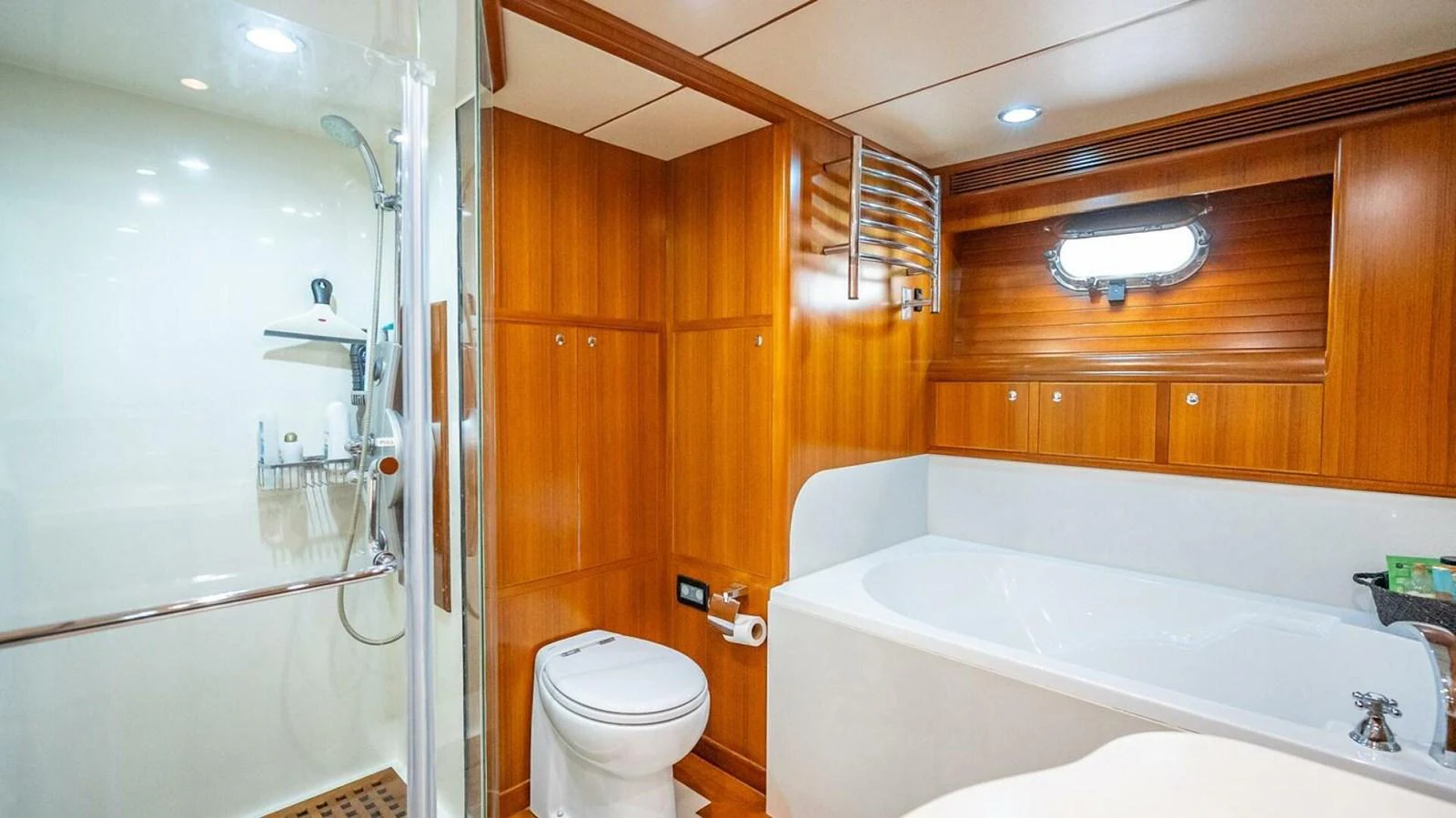 The yacht's bathroom features a spacious layout with a shower, toilet, and bathtub, all accented by warm wood paneling. aboard TAKE 5 Yacht for Sale