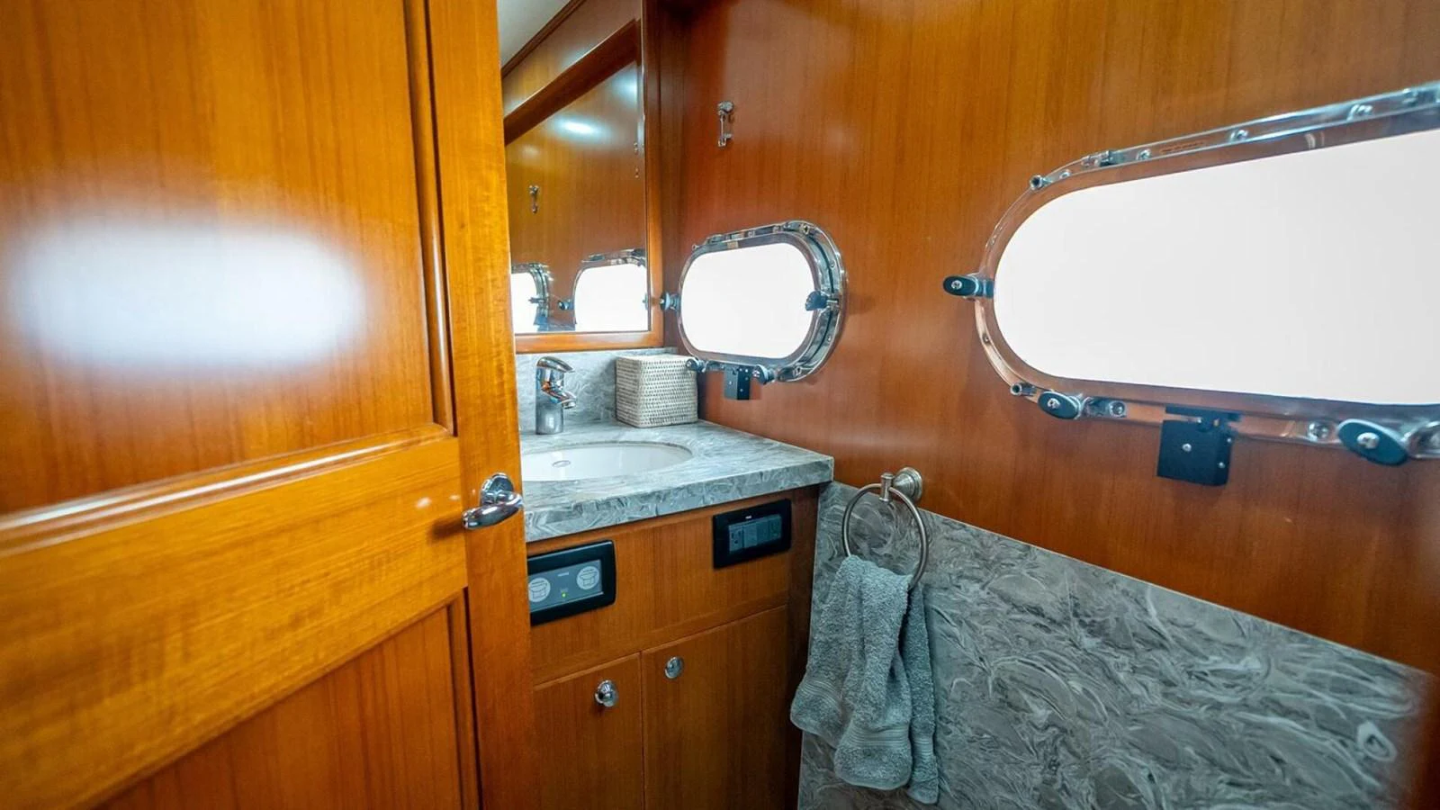 A well-appointed yacht bathroom featuring wooden cabinetry and a marble countertop. aboard TAKE 5 Yacht for Sale