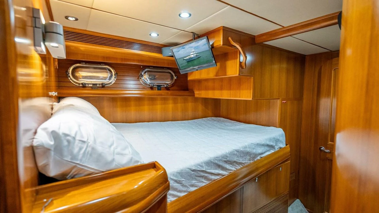 The cozy stateroom features a comfortable bed with warm wood paneling and modern amenities. aboard TAKE 5 Yacht for Sale