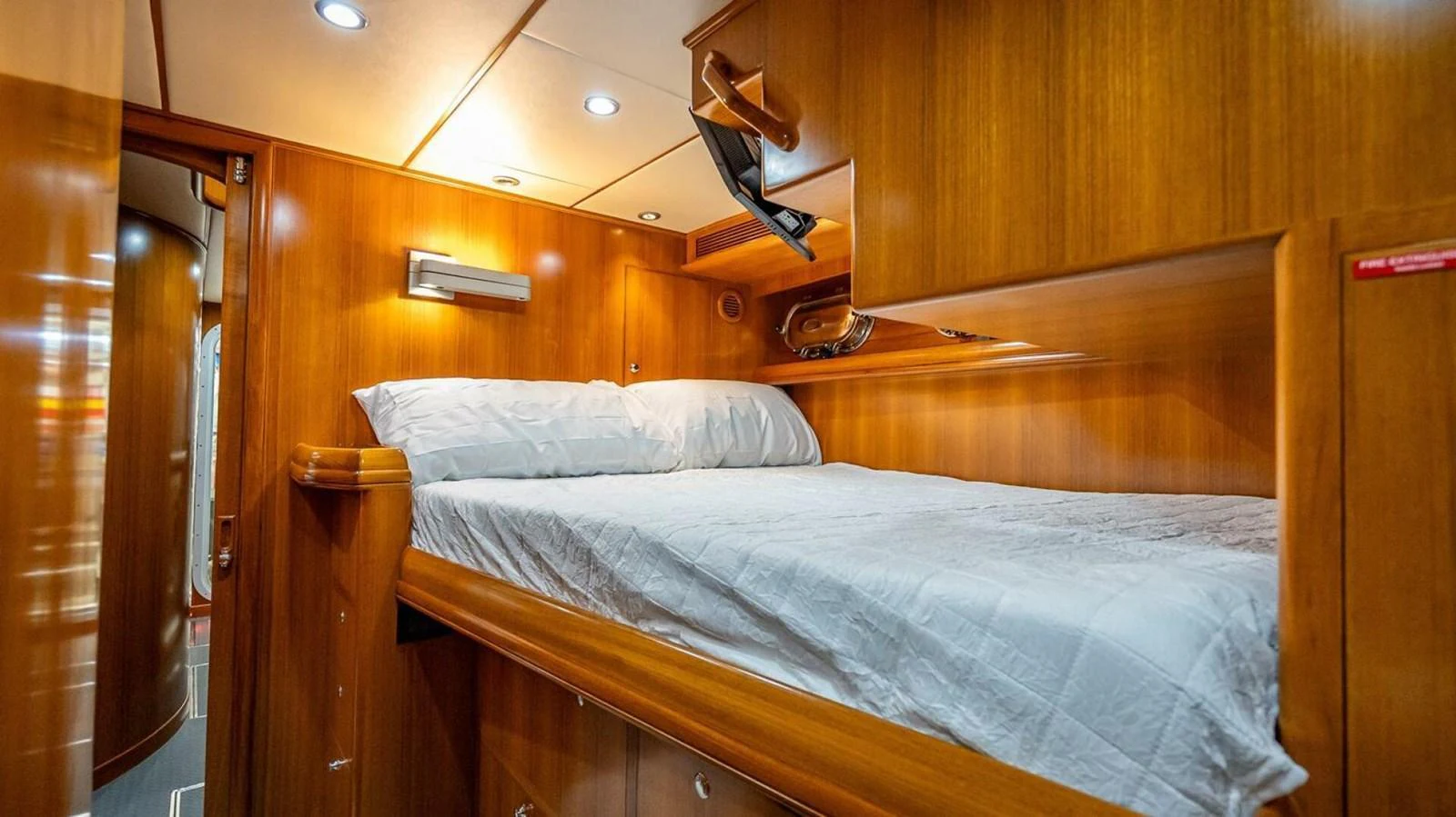 A cozy stateroom with warm wood paneling and a comfortable bed. aboard TAKE 5 Yacht for Sale