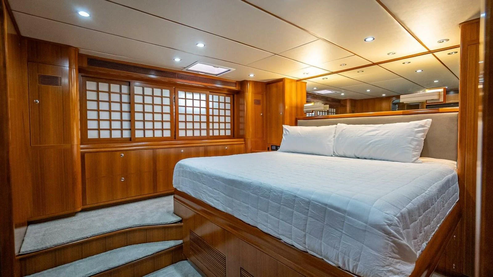 The master stateroom features a spacious bed and elegant wood paneling, creating a luxurious and comfortable retreat. aboard TAKE 5 Yacht for Sale