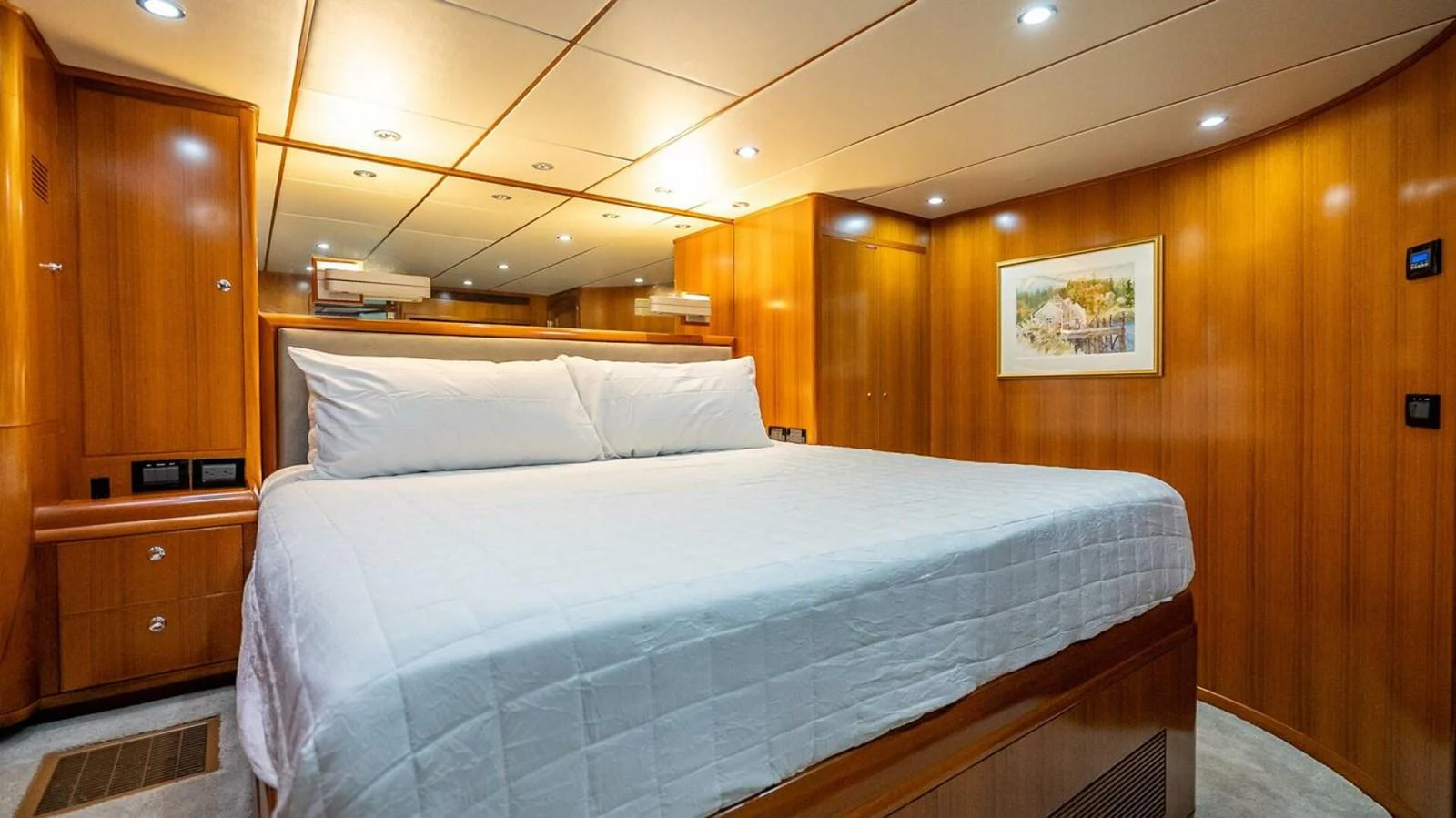 The master stateroom features a spacious bed with warm wood paneling and soft lighting. aboard TAKE 5 Yacht for Sale