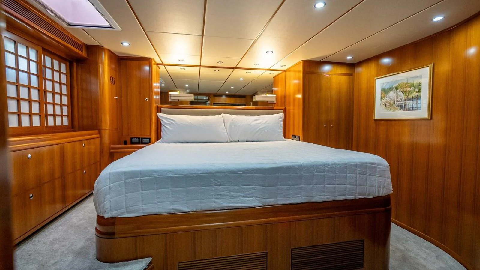 The master stateroom features a spacious bed with elegant wood paneling and ambient lighting. aboard TAKE 5 Yacht for Sale