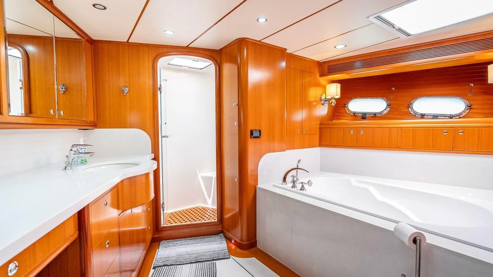 The yacht's bathroom features elegant wood paneling, a spacious bathtub, and modern fixtures. aboard TAKE 5 Yacht for Sale