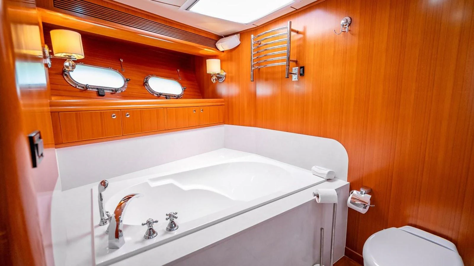 The yacht's bathroom features a luxurious bathtub and elegant wooden paneling. aboard TAKE 5 Yacht for Sale