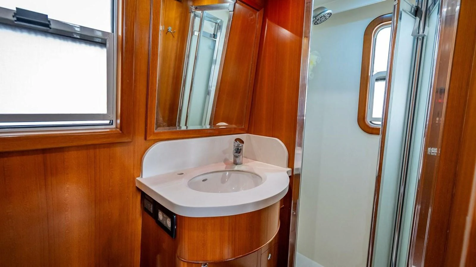 The yacht's bathroom features a sleek sink area with wooden finishes and a modern shower. aboard TAKE 5 Yacht for Sale