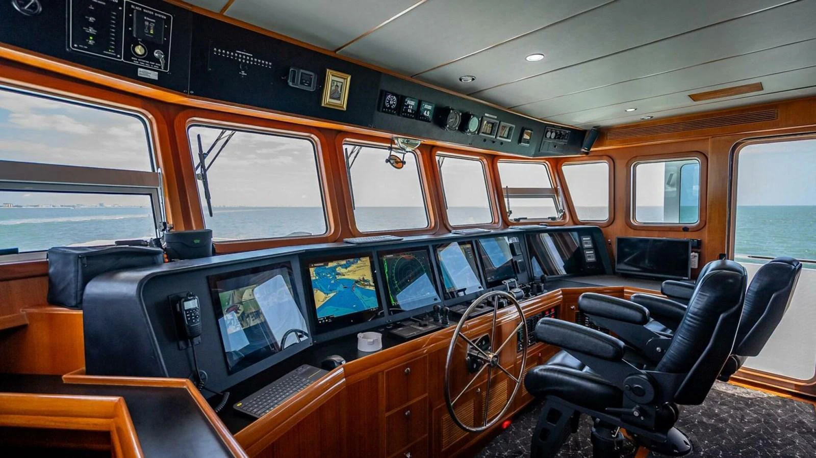 The helm station offers a commanding view with state-of-the-art navigation equipment and luxurious seating. aboard TAKE 5 Yacht for Sale
