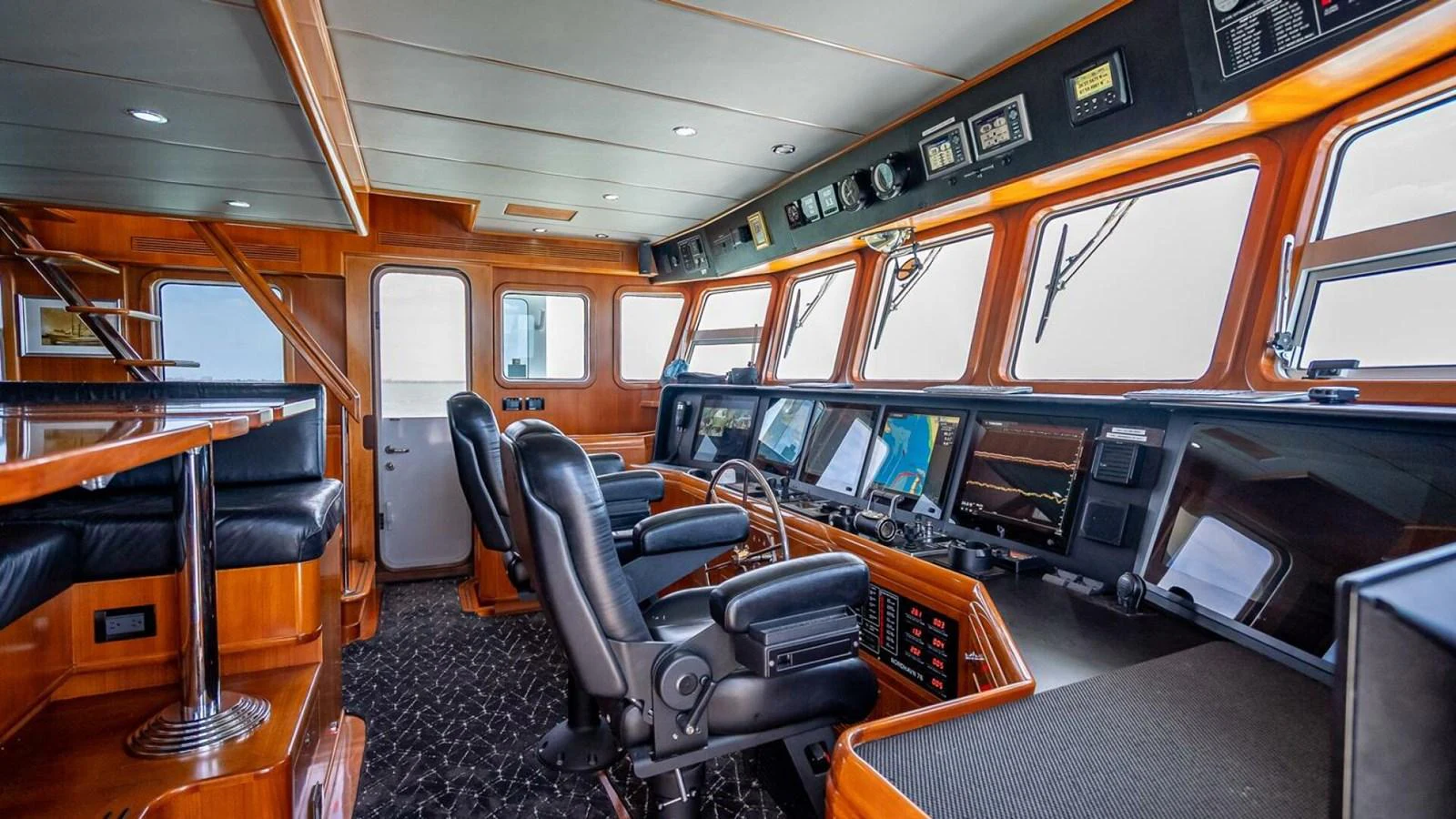 The helm station features advanced navigation equipment and luxurious seating, offering a commanding view for the captain. aboard TAKE 5 Yacht for Sale