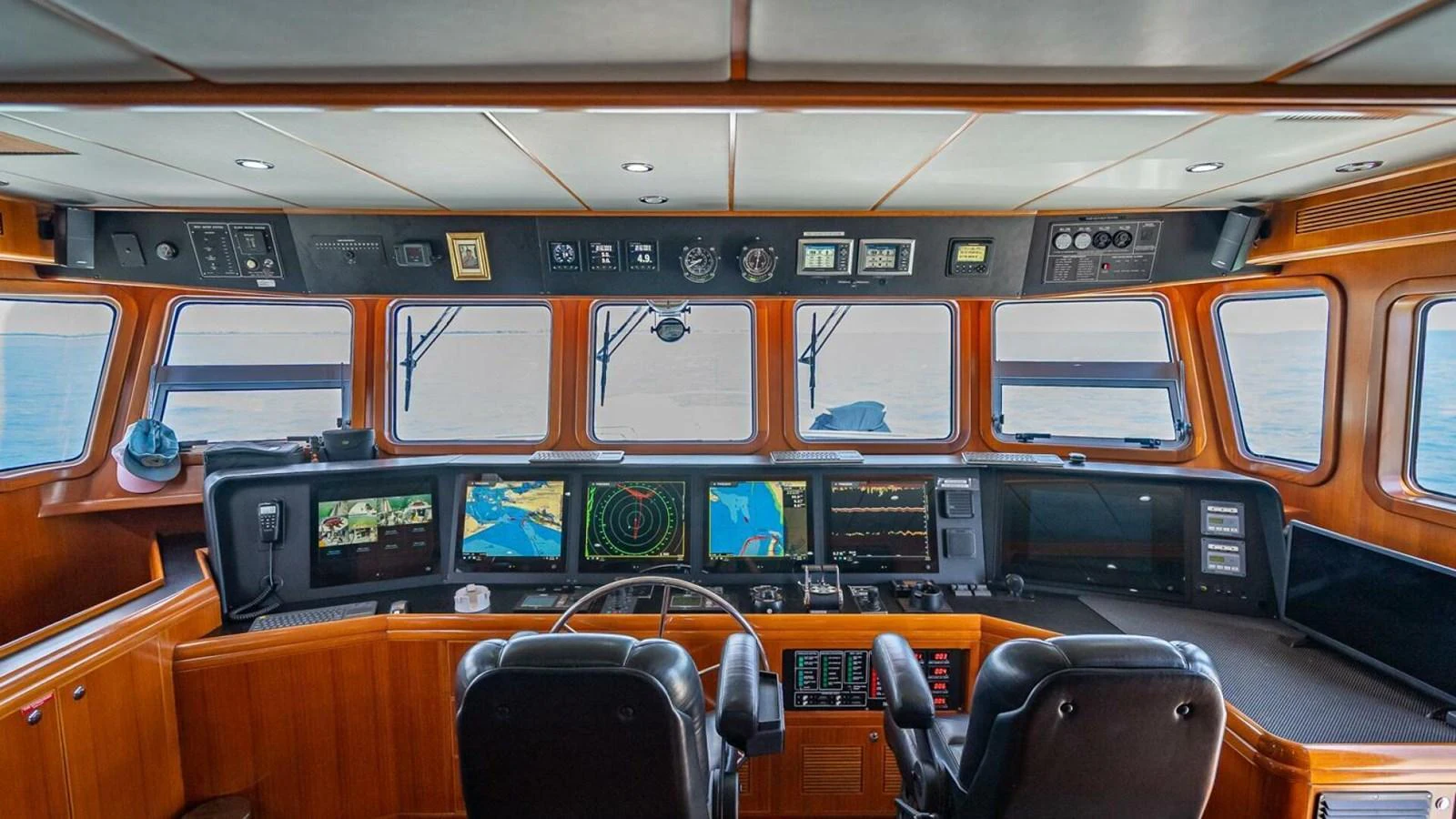 The helm station offers a commanding view with advanced navigation equipment and luxurious seating. aboard TAKE 5 Yacht for Sale