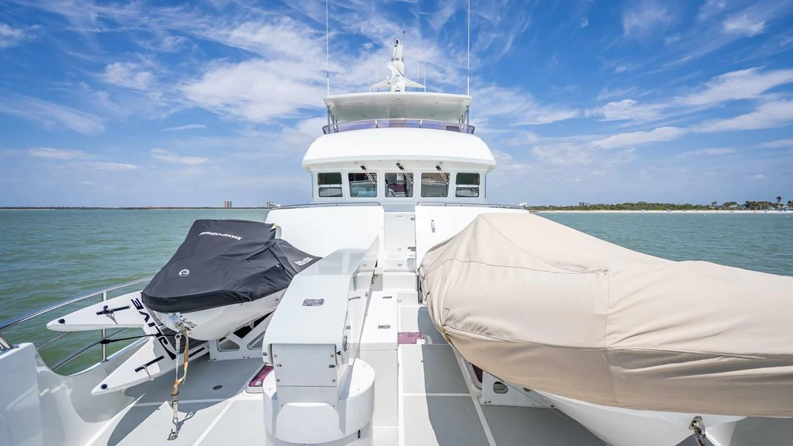 The yacht's foredeck features covered tenders and a clear view of the bridge against a serene seascape. aboard TAKE 5 Yacht for Sale